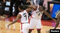 L'ex-pivot des Toronto Raptors, Bismack Biyombo, à droite, avec son coéquipier d'alors Kyle Lowry, Air Canada Centre, 23 mai 2016. 