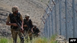 FILE - Pakistani troops patrol along Pakistan-Afghanistan border fence in the Khyber district of the Khyber Pakhtunkhwa province, Aug. 3, 2021. 