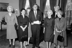 President John F. Kennedy poses with government career women given the Federal Woman’s Award, Feb. 27, 1962. From left: Dr. Allene Jeanes, Dr. Nancy Grace Roman, Evelyn Harrison, Kennedy, Margaret Brass, Katherine Bracken and Dr. Thelma Dunn.