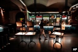 A staff member walks inside a closed bar in Prague, Czech Republic, Oct. 9, 2020. The Czech government has responded to record-high numbers of coronavirus infections by imposing further restrictive measures to contain the surge.
