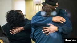 People embrace after learning that their loved one was safe after a mass casualty shooting at the FedEx facility in Indianapolis, Indiana, U.S. April 16, 2021. (Mykal McEldowney/IndyStar/USA Today Network via REUTERS)