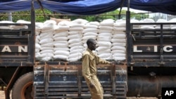 FILE - A truck of maize flour arrives to be distributed to people affected by the lockdown measures aimed at curbing the spread of the new coronavirus, in the Bwaise suburb of the capital Kampala, Uganda, April 4, 2020.