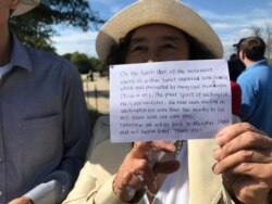 The Zhangs did not speak English but carried a handwritten note about their ancestors' donation. They needed tickets, and a tourist from Dallas gave them her extras. (P. Widakuswara/VOA)