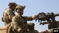 Syria -- Armed men in uniform identified by Syrian Democratic forces as US special operations forces ride in the back of a pickup truck in the village of Fatisah in the northern Syrian province of Raqa, May 25, 2016