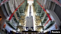 The Shenzhou-9 manned spacecraft, Long March-2F rocket, and escape tower wait to be transferred to the launch pad at the Jiuquan Satellite Launch Center, Gansu province, June 9, 2012.