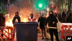 Demonstrators stand at a barricade during protests against the government's decision to suspend negotiations on joining the European Union in Tbilisi, Georgia, early Dec. 3, 2024. 