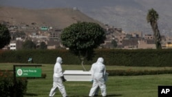 Cemetery workers carry a coffin in Jardines del Buen Retiro cemetery in Lima, Peru, April 25, 2020, during the coronavirus outbreak.