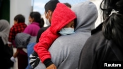 Sejumlah keluarga tampak menunggu di kantor imigrasi di Bandara Internasional La Aurora di Guatemala pada 4 Agustus 2021. Para keluarga tersebut dideportasi dari AS setelah terkena dampak dari kebijakan Title 42. (Foto: Reuters/Luis Echeverria)