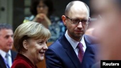 Kanselir Jerman Angela Merkel (kiri) berbicara dengan PM Ukraina Arseniy Yatsenyuk dalam pertemuan pemimpin Uni Eropa di Brussels, Belgia (foto: dok).