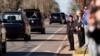 Un niño saluda al coche fúnebre que transporta el féretro, cubierto con la bandera estadounidense, del expresidente Jimmy Carter, mientras avanza por el centro de Plains, Georgia, el 4 de enero de 2025. 