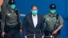 香港传媒大亨、《苹果日报》创始人黎智英(中)在香港出庭前被惩教署人员押送上一辆囚车。(2020年12月12日)