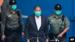 香港傳媒大亨、《蘋果日報》創始人黎智英(中)在香港出庭前被懲教署人員押送上一輛囚車。 (2020年12月12日)