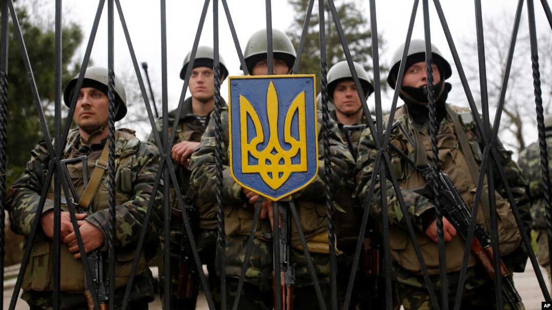 Tentara Ukraina berjaga di sebuah gerbang markas tentara infanteri di Privolnoye, Ukraina, Minggu (2/3). 