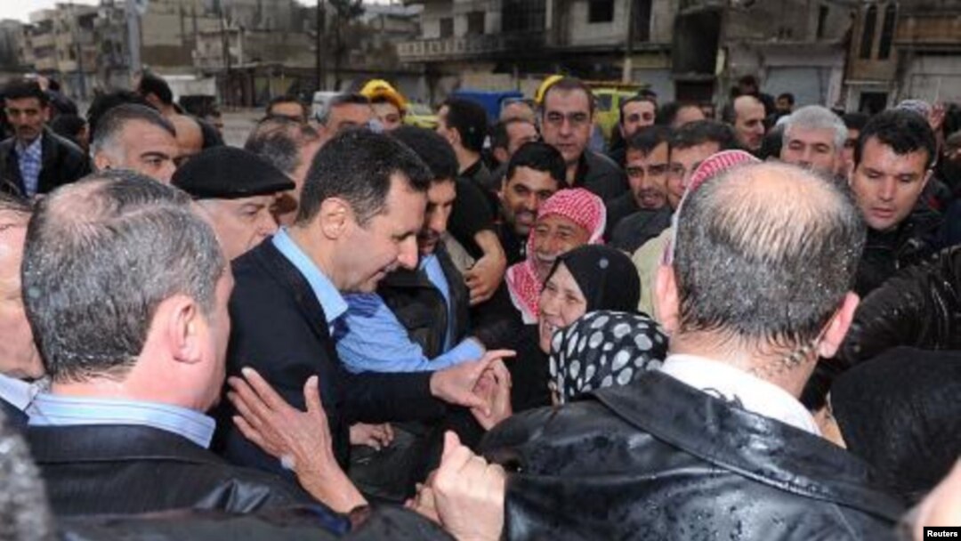Presiden Suriah Bashar al-Assad (tengah) mengunjungi para pendukungnya di distrik Baba Amr, kota Homs (27/3). 