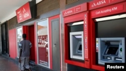 Un homme marche devant une banque, à Cape Town,6 décembre 2012.