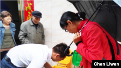 Chen Liwen, along with Dongyang villagers, examines a recycling can to see if there's garbage inside and if it is in the correct can, July, 2019. (Courtesy: Chen Liwen, Founder of Zero Waste Village (China)) 