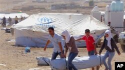 Pengungsi Suriah mendapatkan tenda bantuan dari UNHCR, setibanya di sebuah tempat penampungan pengungsi darurat di wilayah Irbil, 350 kilometer di utara Baghdad, Irak, 16 Agustus 2013 (Foto: dok). 