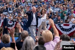 Wakil Presiden AS sekaligus calon presiden dari Partai Demokrat Kamala Harris dan pasangannya Gubernur Minnesota Tim Walz menyapa khalayak selama acara kampanye di Eau Claire, Wisconsin, AS, 7 Agustus 2024. (Foto: REUTERS/Erica Dischino)