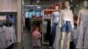 A child plays with a balloon at a clothing store having a promotion sale in Beijing, July 15, 2019. China's economic growth sank to its lowest level in at least 26 years.