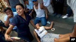 Ruben Mero, is assisted by a paramedic after he was overcome with grief during the funeral of his niece Kexly Valentino who died in the earthquake, in Montecristi, Ecuador, April 19, 2016. 