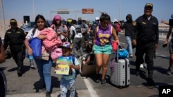 Migrantes venezolanos son escoltados por la policía peruana a una oficina de migración en la frontera con Chile en Tacna, Perú, el 28 de abril de 2023.