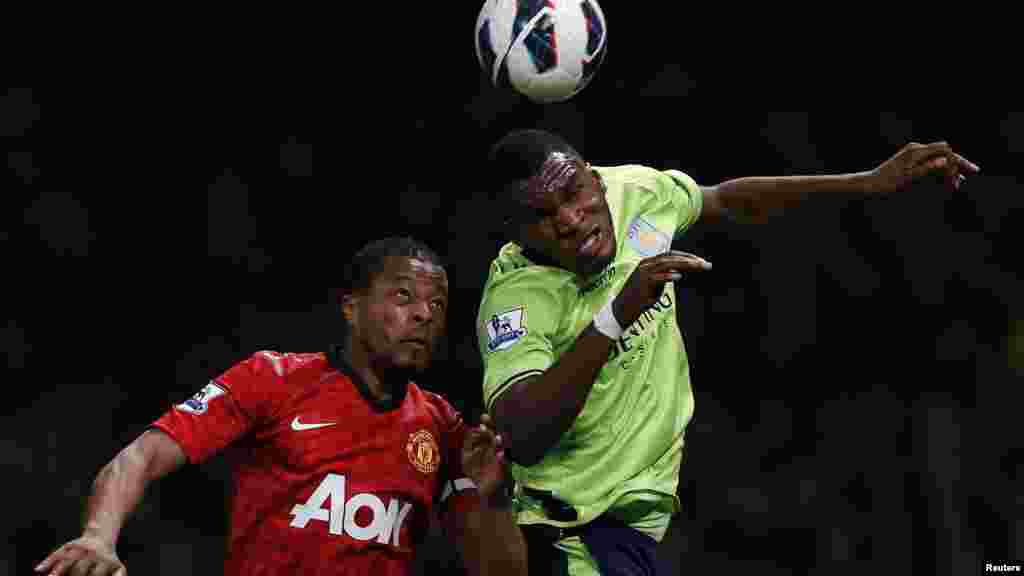 Manchester United's Patrice Evra (L) challenges Aston Villa's Christian Benteke during their English Premier League soccer match at Old Trafford in Manchester, northern England, April 22, 2013.