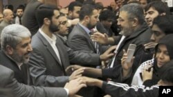 Hamas leader Khaled Meshaal (l) greets members of the 'Asia 1' convoy after a meeting in Damascus, 22 Dec 2010