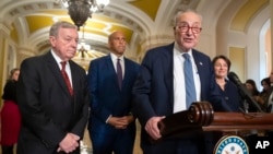 FILE - Senate Majority Leader Chuck Schumer of New York speaks with reporters as, from left, Sen. Dick Durbin, Sen. Cory Booker, and Sen. Amy Klobuchar, listen on Capitol Hill, Dec. 3, 2024, in Washington.