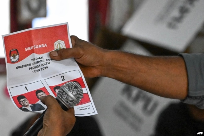 Seorang petugas pemilu menghitung surat suara di sebuah tempat pemungutan suara di Banda Aceh, usai Pilkada serentak, 27 November 2024, (CHAIDEER MAHYUDDIN / AFP)