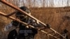A Mexican National Guard officer holds a ladder suspected to have been used by migrants to cross the border through the border fence wall into the United States.