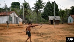 A member of Uru Eu Wau Wau tribe holds up a rifle in the tribe's reserve in the Amazon, south of Porto Velho, Brazil, Aug. 29, 2019.