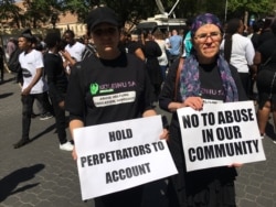 Two female protesters display signs denouncing abuse against women, Sept. 13, 2019. (T.Khumalo/VOA)