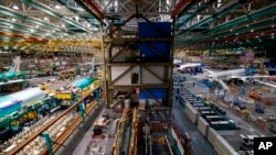 FILE - The 777 factory line, left, is seen next to the 787 line, right, at Boeing's Everett Production Facility, June 15, 2022, in Everett, Wash. 