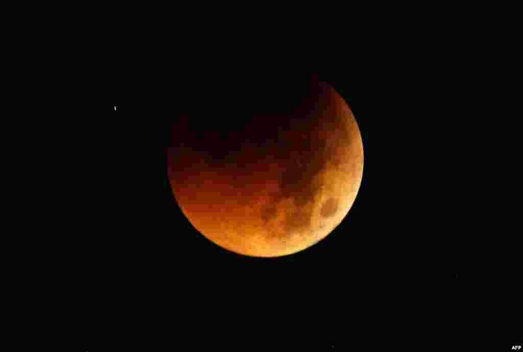 Bayangan bumi terlihat di bulan dalam gerhana bulan total yang terlihat di Manila, Filipina ini, sebelum subuh pada hari Kamis (AP Photo/Bullit Marquez).