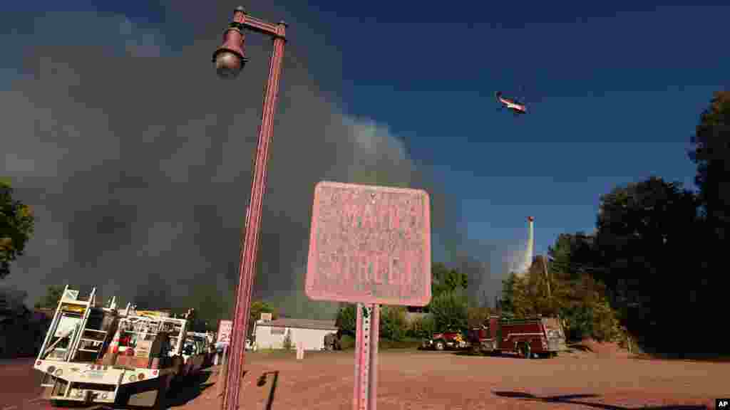 Un hélicoptère bombardier d&#39;eau répand un produit ignifugé&nbsp; sur la région en proie aux incendies,&nbsp; le 14&nbsp;août 2016.