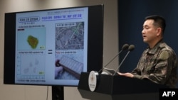 지난 5일 서울 국방부 브리핑룸에서 합동참모본부 양진혁 작전부장이 비무장지대(DMZ) 지뢰 폭발 사건의 공동조사단 최종 결과에 대해 브리핑하고 있다. 화면 상단(오른쪽 위)은 폭발 현장에서 수거된 지뢰 파편이며, 하단(오른쪽 아래)은 과거 수거된 북한군 목함지뢰의 모습이다. 한국 군과 유엔군사령부 조사단은 DMZ 내에서 발생해 장병 3명을 다치게 한 지뢰 폭발 사고의 원인이 북한군이 매설한 지뢰 때문이라는 결론을 내렸다고 군 당국이 이날 발표했다.