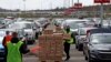 Relawan dari Greater Pittsburgh Community Food Bank, membagikan kotak makanan di tempat parkir yang dikosongkan akibat pandemi Covid-19, di Bandara Internasional Pittsburgh, Rabu, 22 April, 2020. (Foto: AP/Gene J. Puskar)