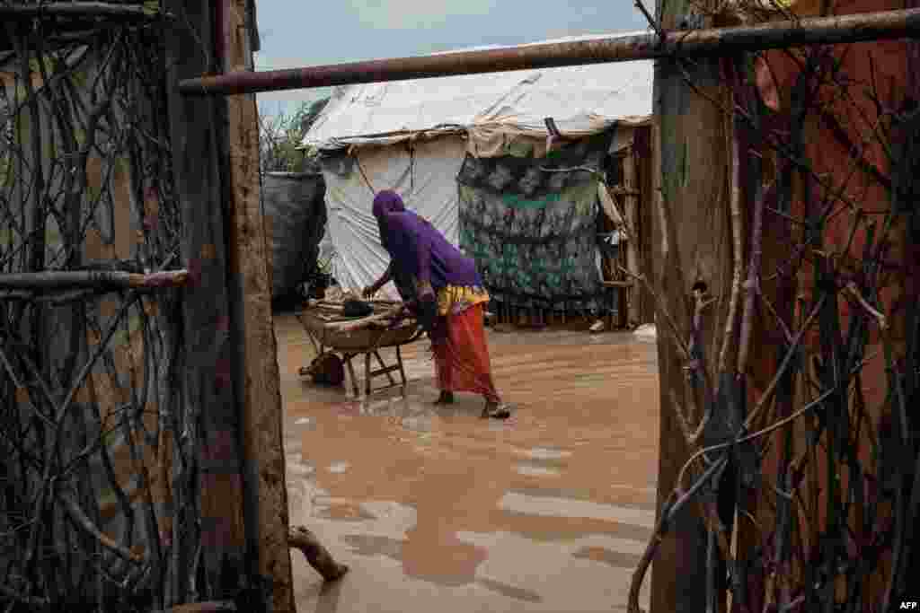 케냐-소말리에 국경에서 30만 명 이상이 거주하는 세계 최대 &#39;다답&#39; 난민촌이 폭우로 인해 침수된 가운데, 여성이 외바퀴 손수레에서 요리하고 있다.