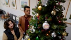 Mohammad Attaie and his wife Deena, newly arrived from Afghanistan, look over ornaments on a Christmas Tree at the Valley Health Center TB/Refugee Program in San Jose, California, on Dec. 9, 2021.