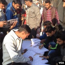 Voters in Ghaziabad in the battleground Uttar Pradesh state who went to the polls Saturday to choose a regional government turn up early to search for their names in the voters list. (A. Pasricha/VOA)