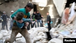 2月2號阿薩德軍隊轟炸阿勒頗，一名男子懷抱從瓦礫下挖出的一名受傷的孩子。
