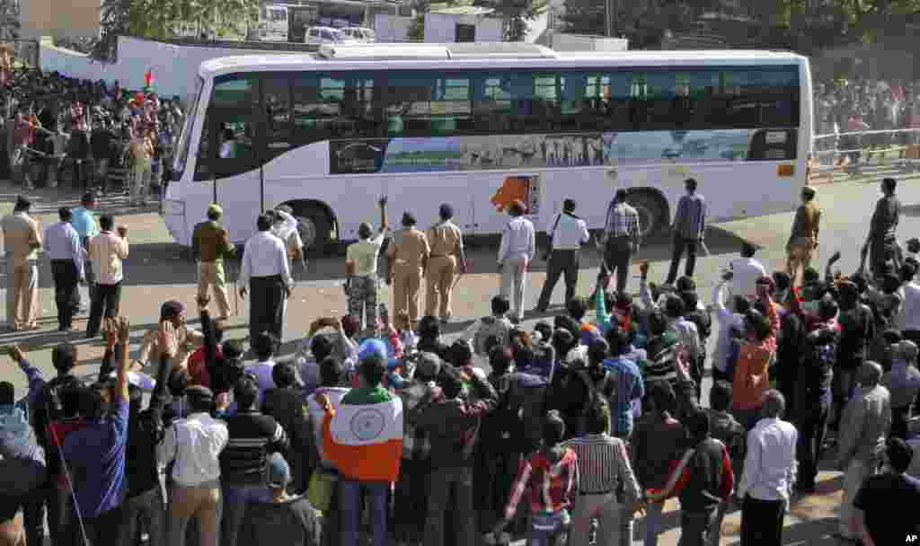 Indian cricket fans wave towards a bus carrying Pakistani cricket players, outside the Sardar Patel Stadium, December 28, 2012. 
