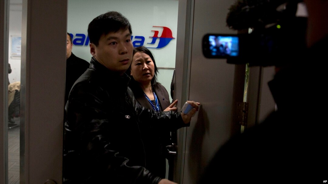 Petugas Malaysian Airlines berusaha menghindari pertanyaan dari wartawan di Bandara Internasional Beijing, China, Sabtu (8/3).