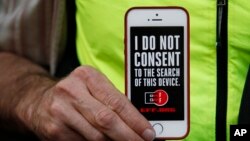 A man holds up his iPhone during a rally in support of data privacy outside an Apple store in San Francisco, Calif., Feb. 23, 2016. Protesters lashed out at a government order requiring Apple to help unlock an encrypted iPhone.