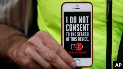 Čovek drži ajfon na kojem piše "Ne pristajem da se ovaj telefon pretražuje" na protestu u San Francisku, 23. februar 2016.