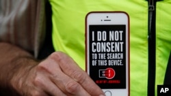 A man holds up his iPhone during a rally in support of data privacy outside an Apple store in San Francisco, Calif., Feb. 23, 2016. Protesters lashed out at a government order requiring Apple to help unlock an encrypted iPhone.