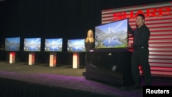 Models stand by a ICC Purios Ultra HD television at a Sharp news conference during the Consumer Electronics Show (CES) in Las Vegas January 7, 2013. Seen in the background are new Aquos 8-Series televisions and a 90-inch LED Smart 3D TV (far left). Sharp 