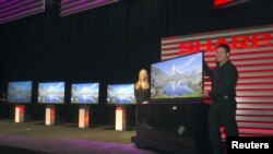 Models show a ICC Purios Ultra HD television at a Sharp news conference during the Consumer Electronics Show (CES) in Las Vegas January 7, 2013. Seen in the background are new Aquos 8-Series televisions and a 90-inch LED Smart 3D TV (far left). Sharp 