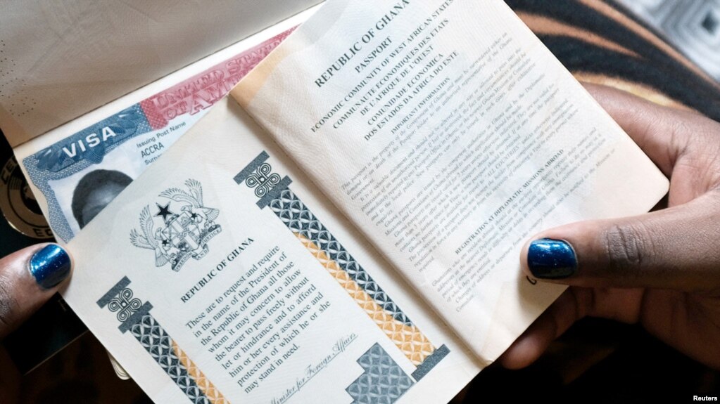Une femme montre les passeports de sa famille avec un visa américain à Accra, au Ghana, le 1er février 2019. Le Ghana n'est pas inclus dans le programme de garantie monétaire.