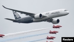 FILE - An Airbus A350 aircraft flies in formation with Britain's Red Arrows flying display team at the Farnborough International Airshow in Farnborough, Britain, July 15, 2016.